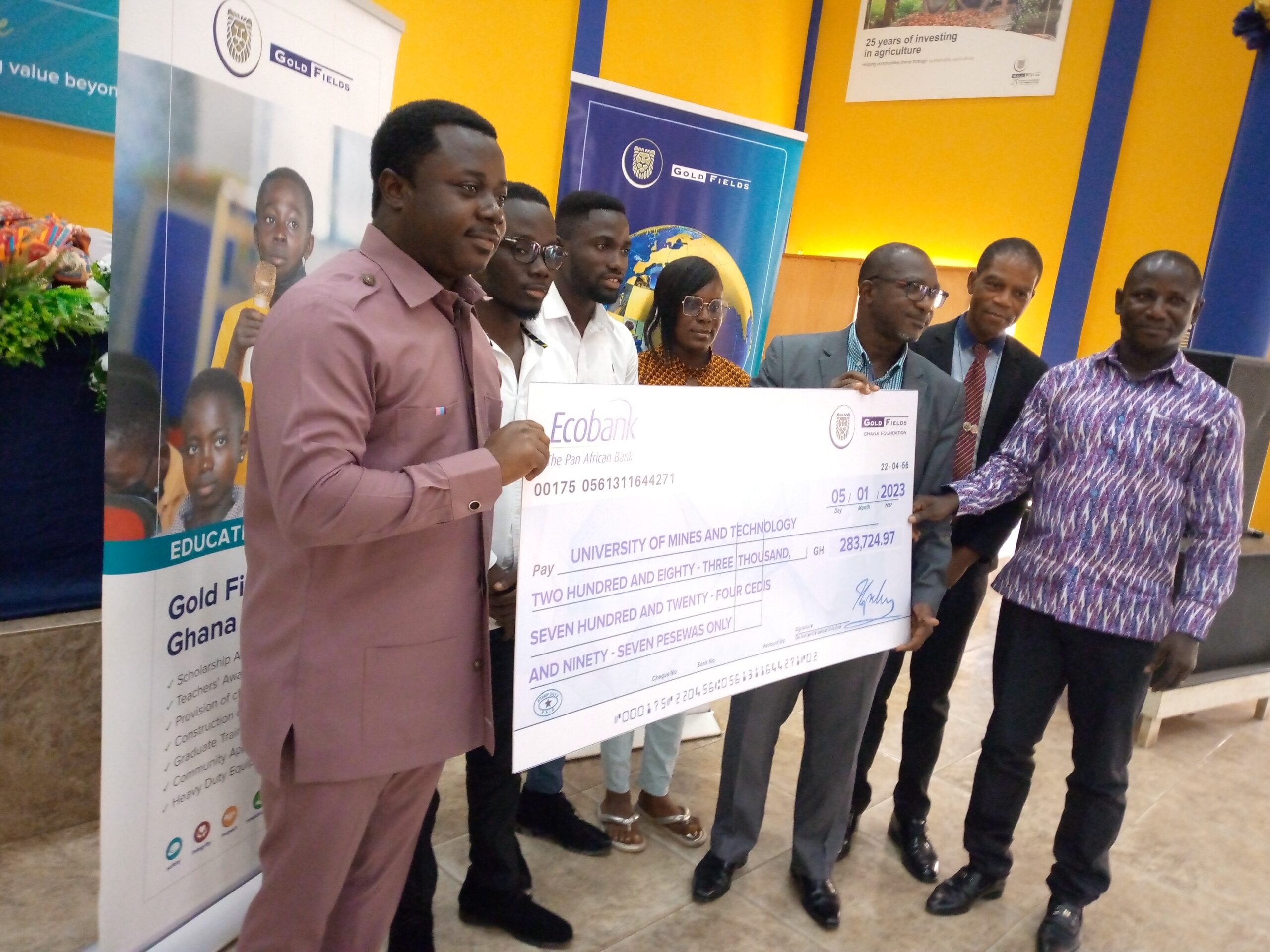 Rev. John Ntim Fordjour, Deputy Education Minister presenting the bulk cheque payment to one of the University. Inset is parents of beneficiaries at the programme