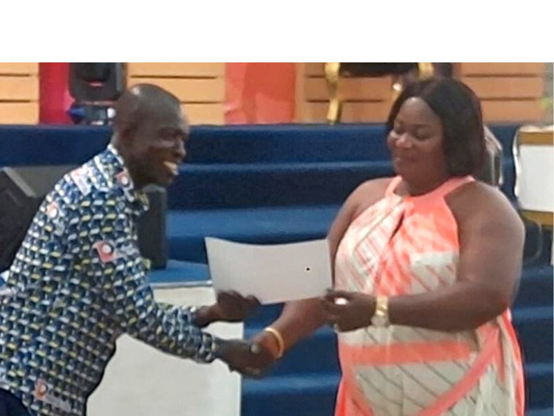 Mrs. Fosu, wife of the CEO of Prefos Ltd presenting an award to the Overall Best administrative Officer (Southern Sector)