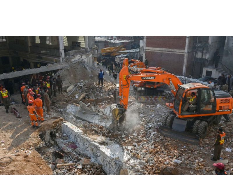 Security personnel and rescue workers search for victims after Monday's blast at a mosque in Peshawar, Pakistan