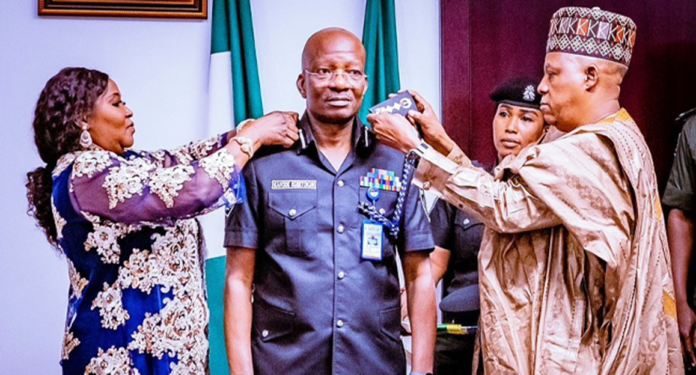 Vice President Kashim Shettima (R) and Mrs Egbetokun (L) decorate the new acting Inspector General of Police, Kayode Egbetokun