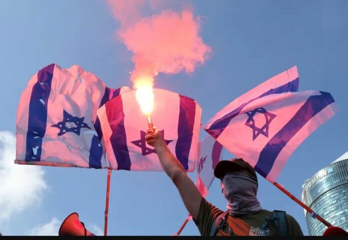 Demonstrators use flares as they stage a 'day of resistance' to protest the Israeli government's judicial overhaul bill, in Tel Aviv
