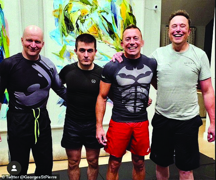 Elon Musk (right) underwent a gruelling training session with UFC legend Georges St Pierre (red shorts)