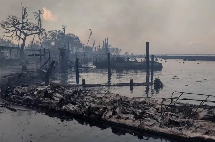 A charred boat lies near the scorched waterfront after wildfires devastated Maui’s city of Lahaina, Hawaii