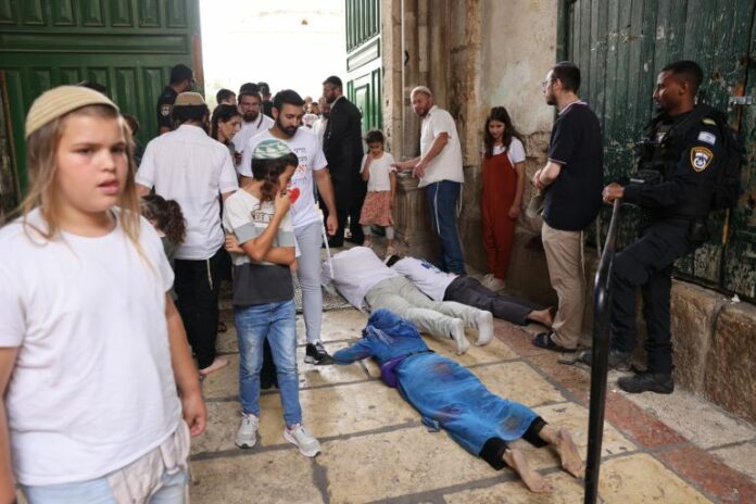 Jewish men prostrate on the ground in prayer outside the gate of the Al-Aqsa Mosque compound, also known as Temple Mount in occupied East Jerusalem