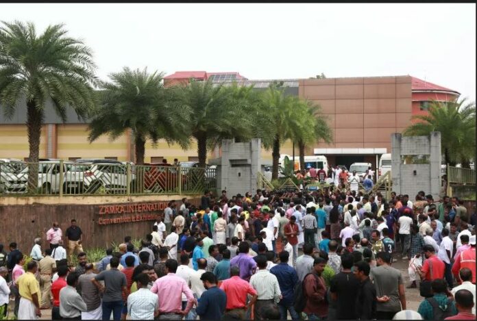People stand outside a convention centre where a blast occurred during a religious gathering in Kochi, India
