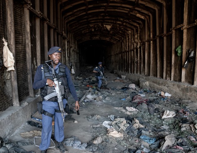 South African police guard the entrance to an abandoned mine in Stormhill, west of Johannesburg, on August 10