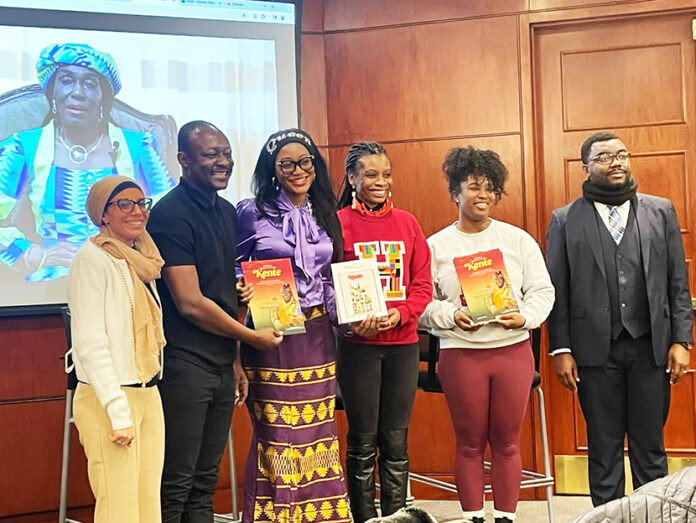 The students display the Kente documentary film premiere booklet in a pose with film producer (3rd left)