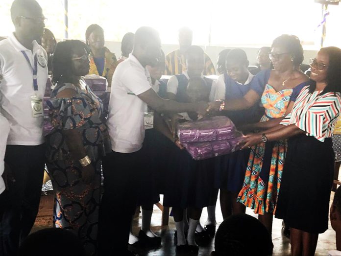 Mr. Debrah Bekoe Isaac, the CEO of As I Grow in a symbolic presentation to an official of the school
