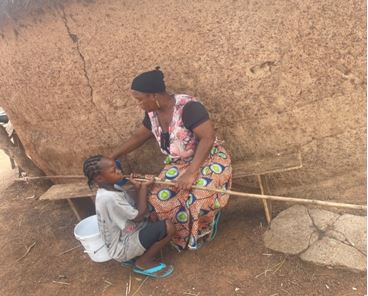 Amina Seidu, mother of Ayisha with one of her children. She worries about the impact of dust on their health