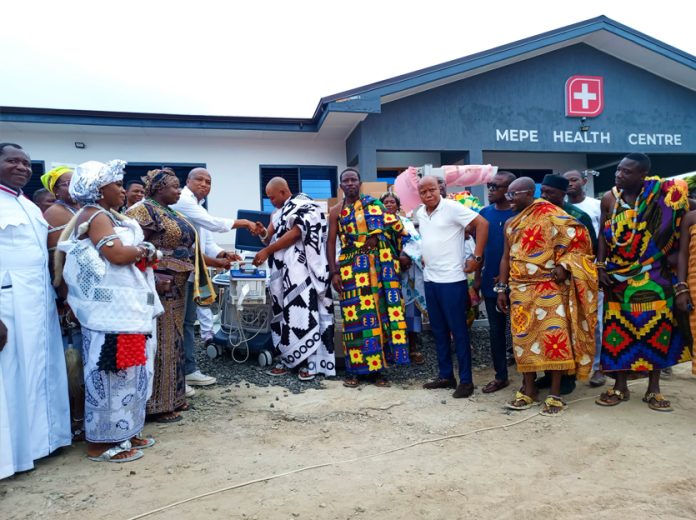 Ablakwa (left) presenting one of the medical items to a traditional leader for onward delivery to the health centre