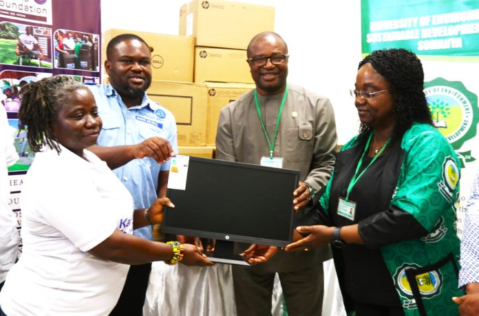 Mr. Henry Larbi ( in sea blue shirt) of the Kabaka Foundation presenting the laptop to management of USED