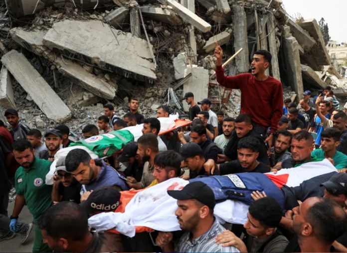 Mourners carry one of the bodies of the Al Jazeera staff who were killed in an overnight Israeli strike