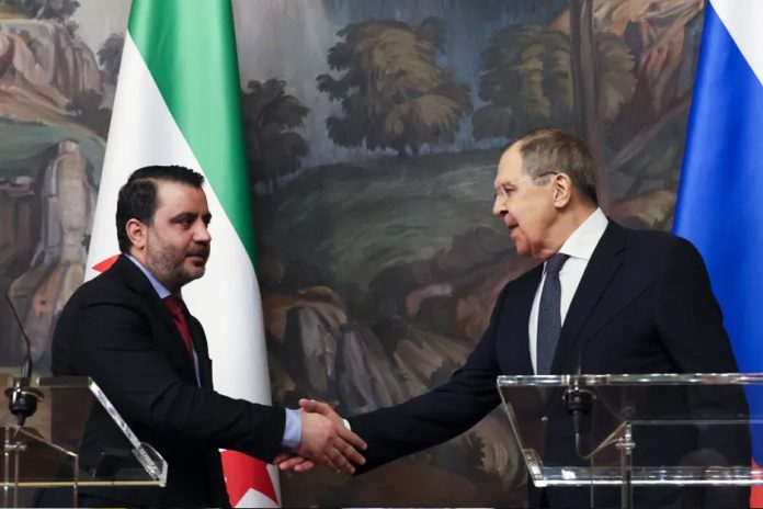 Russian Foreign Minister Sergey Lavrov, right, and Syrian Foreign Minister Asaad al-Shaibani shake hands