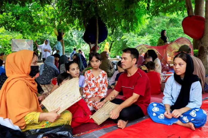Afghan citizen Suleman Baig sits with his family