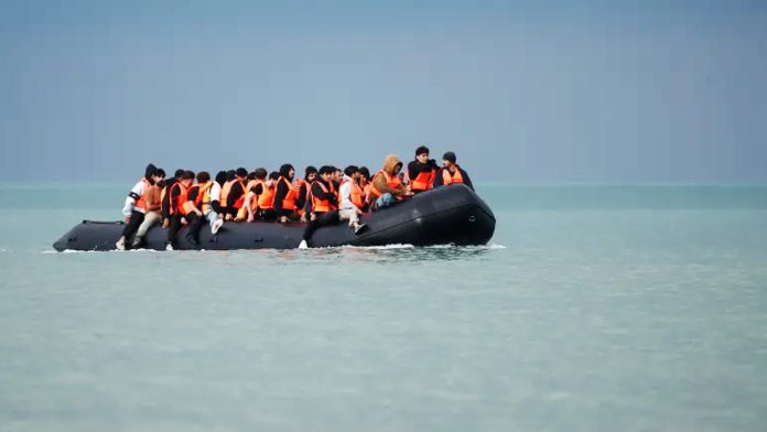 Migrants and refugees on an inflatable dinghy attempt to cross the English Channel