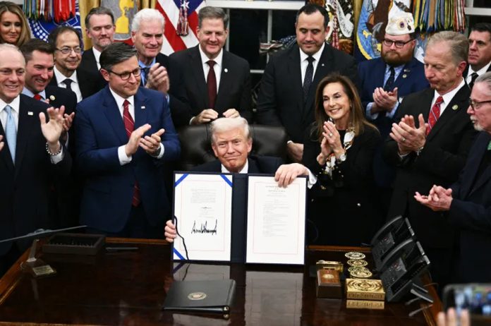 US President Donald Trump shows the signed bill to reopen the federal government