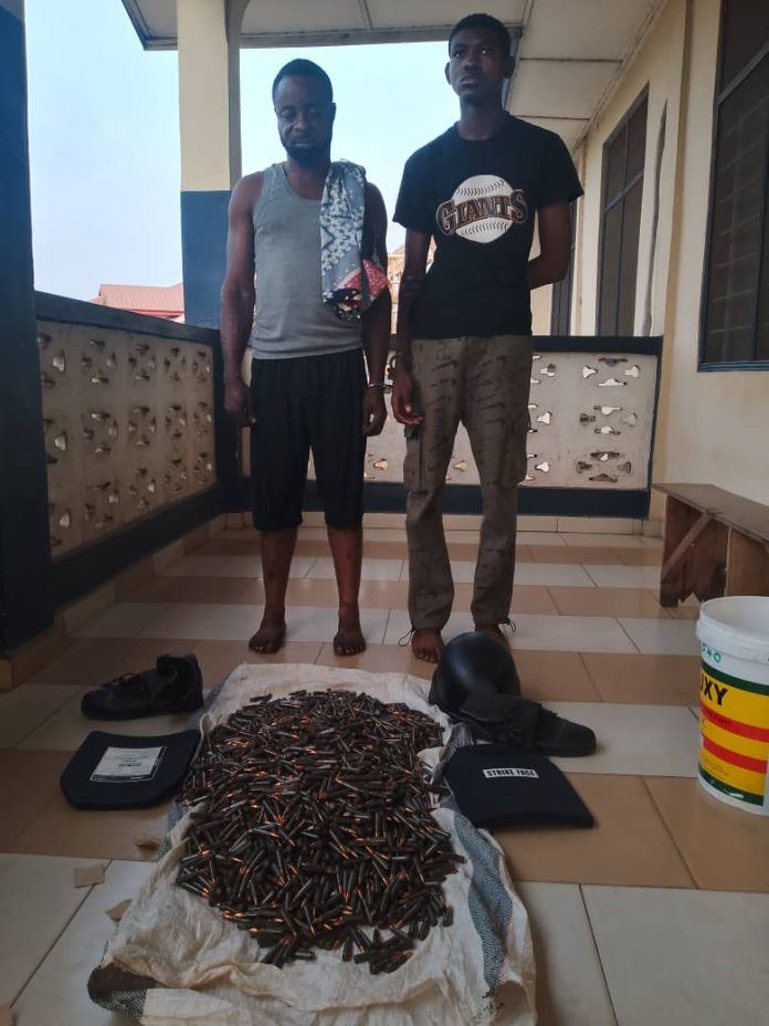 Two suspects pictured with exhibits retrieved from their vehicle.