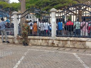 Military personnel stationed outside the court to ensure security and order during proceedings.