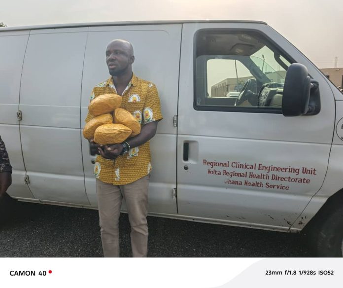 Suspect Godsway Kwaku Dogbey, 38 with some of the exhibits; in the background is the GHS car