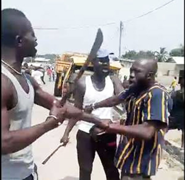 Two men wielding machetes during a violent confrontation, as another man attempts to flee.