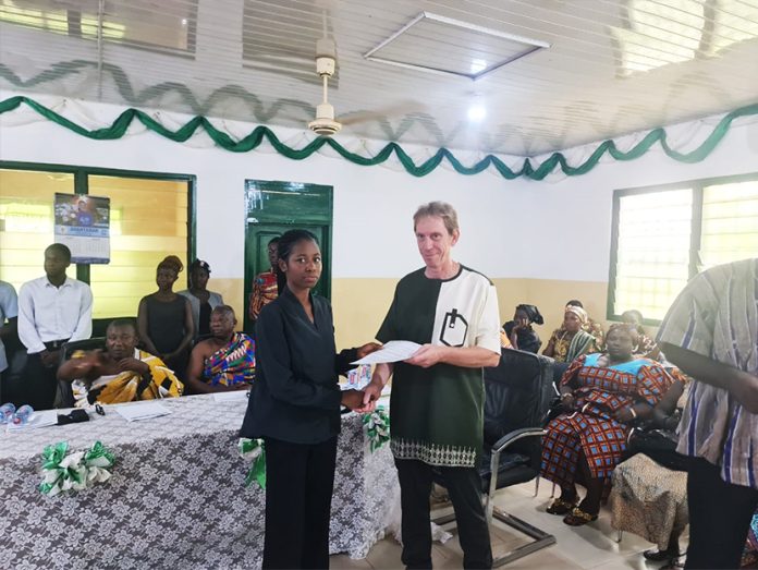 GREL MD Thierry Couchy presenting a scholarship package to a female beneficiary