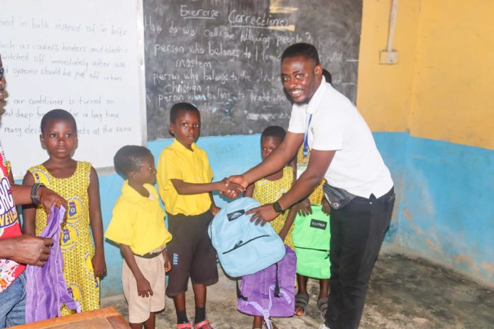 The Chief Executive Officer (CEO) of As I Grow Organization, Mr. Isaac Debrah Bekoe presenting some of the items to some section of the pupils during the donation exercise.