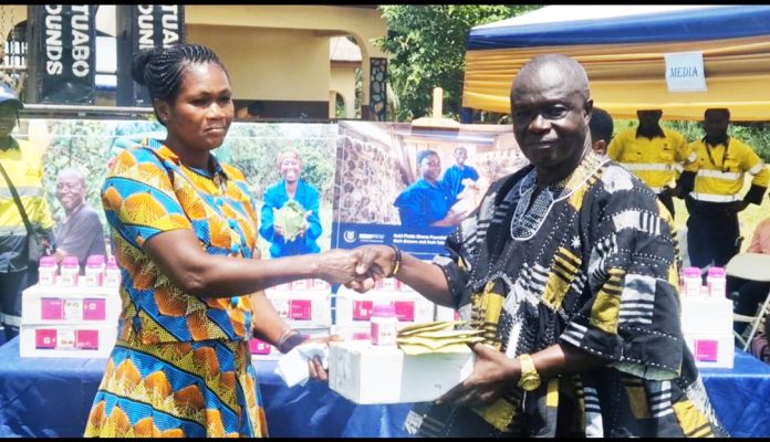 Mr. Mumuni ,cocoa health Extension Director handing a package to another cocoa farmer
