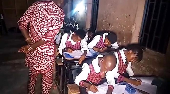 Students writing WAEC exam at night