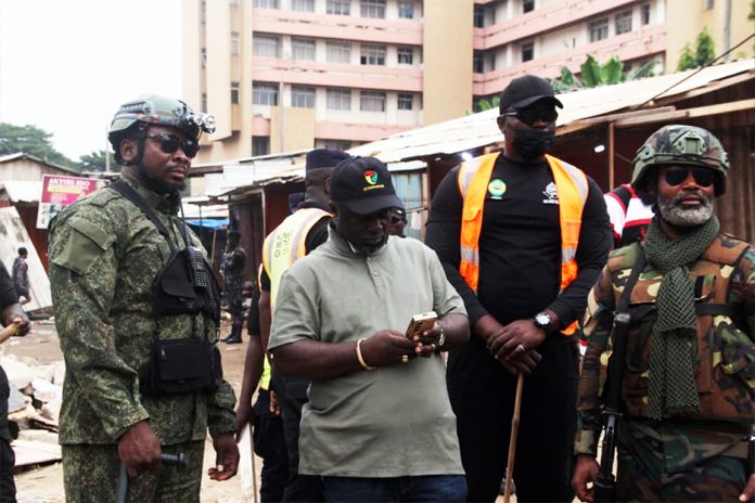 The mayor of Kumasi (middle) flanked by military personnel while supervising the demolition exercise