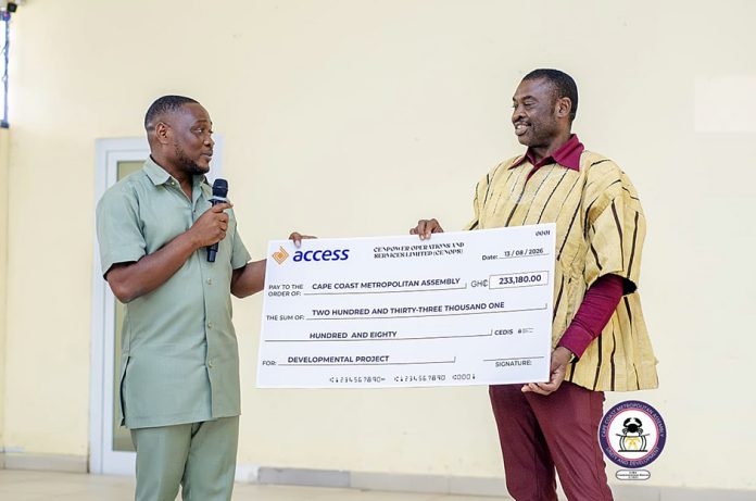 The MCE of Cape Coast, George Justice Arthur handing the cheque to the Metro Coordinating Director of the CCMA