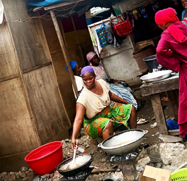 Salma Iddrisu fries food at her makeshift stall at the Ashaiman scrapyard, where she has worked for the past six years