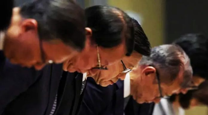 John Lee (centre) bowed in apology along with top officials