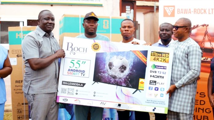 Kwabena Owusu Nketia (extreme left) receiving the items from Eric Addae Boateng (2nd left) while staff of the Assembly look on