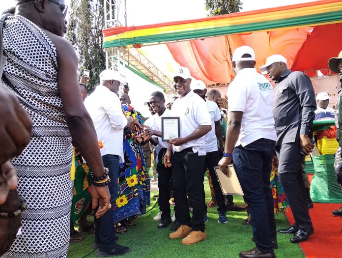 Lands Minister Armah Kofi-Buah presenting a certificate to one of the cooperatives in Nkroful