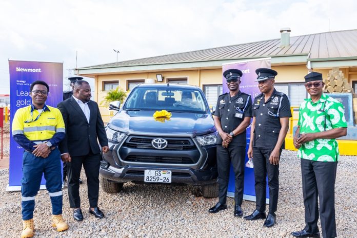 Newmont and police officials standing in front of the donated vehicle